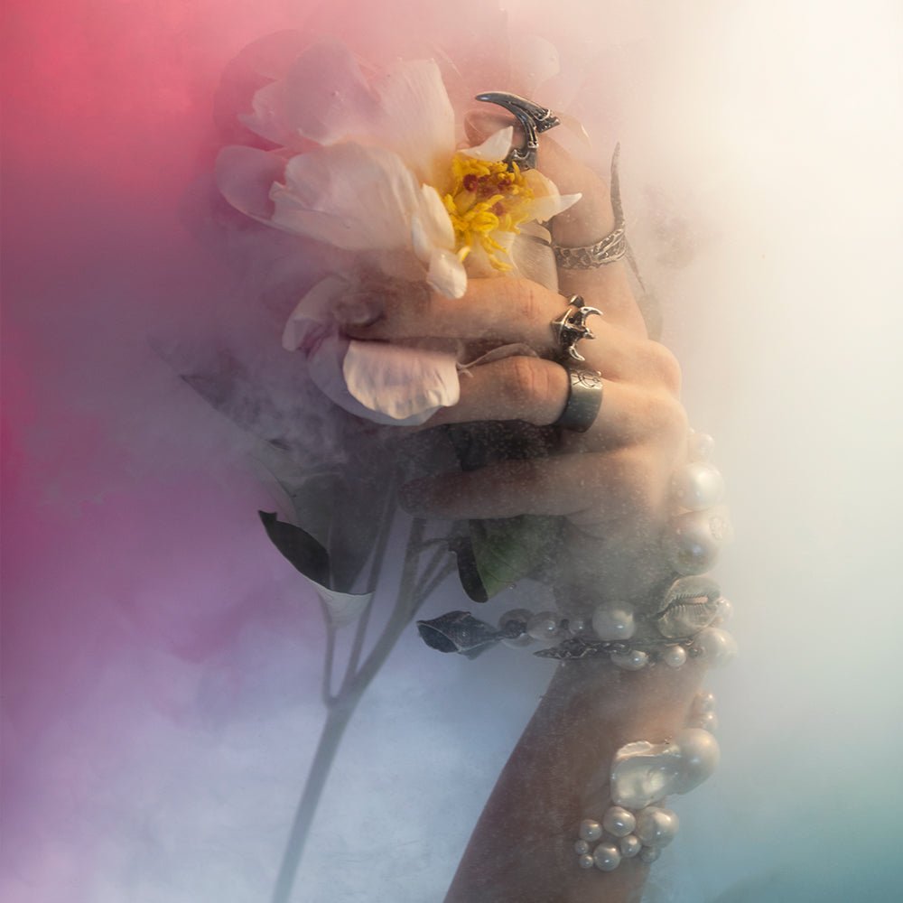 Model wearing several rings by Macabre Gadgets including Vertebra ring in colourful water - underwater fashion editorial